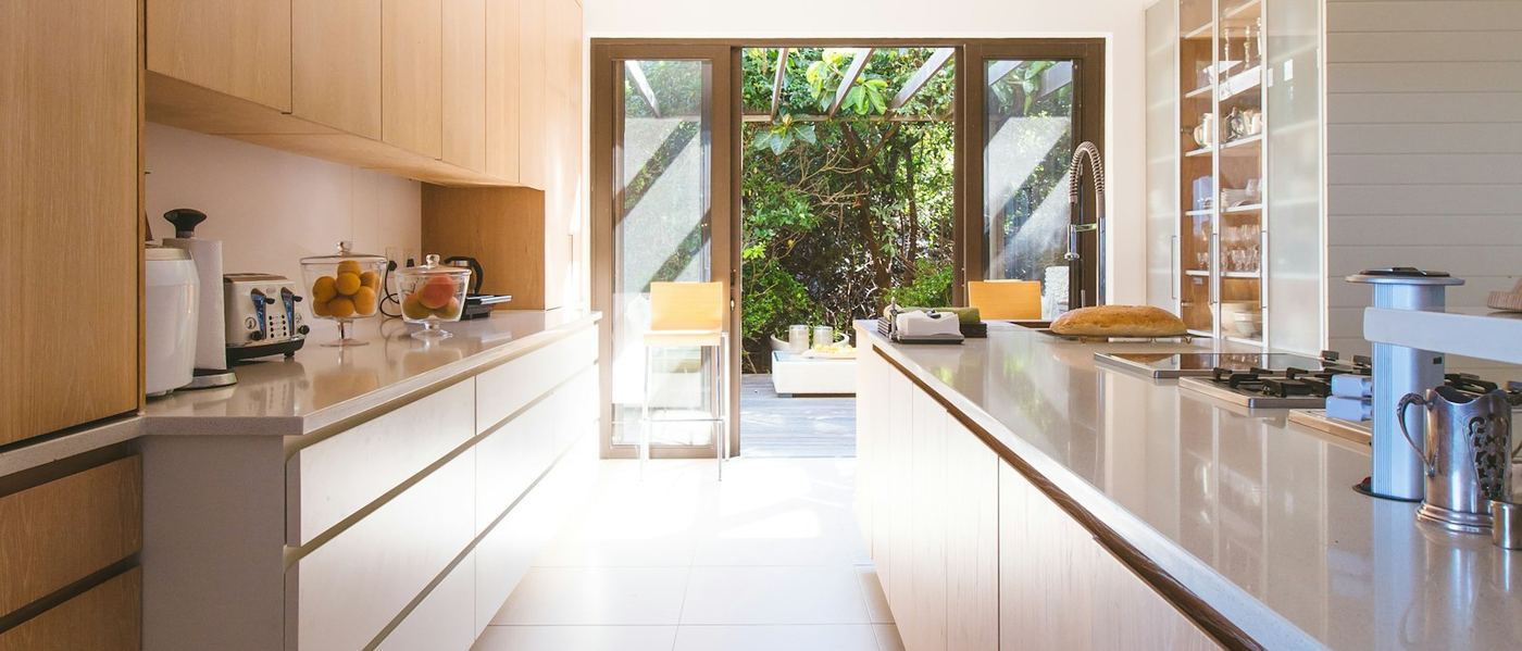 Custom wood cabinetry surrounding a built-in kitchen island, the kind of millwork a panel-ready repair must not mark